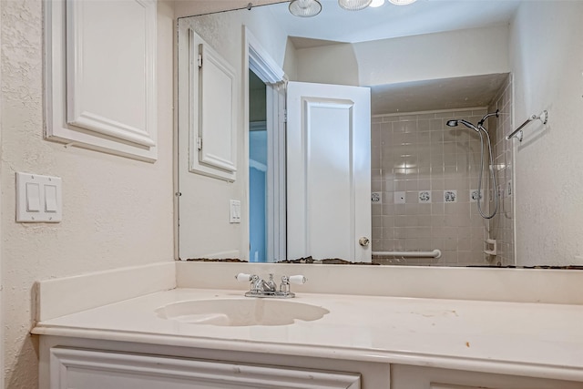 bathroom with vanity and tiled shower