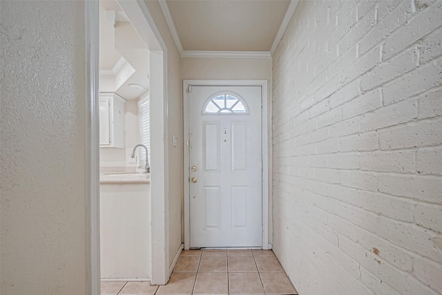 entryway featuring ornamental molding, sink, brick wall, and light tile patterned floors