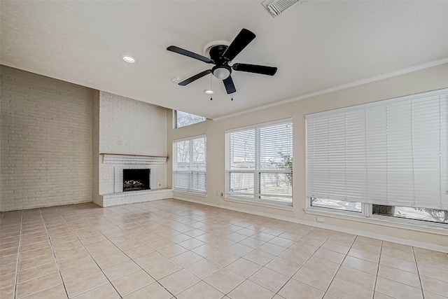 unfurnished living room featuring a fireplace, ceiling fan, brick wall, and light tile patterned floors