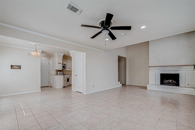 unfurnished living room with brick wall, ceiling fan, crown molding, a fireplace, and light tile patterned floors