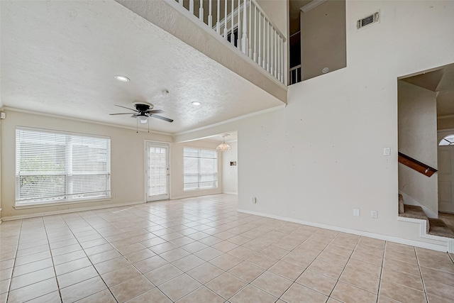 empty room featuring light tile patterned floors, ceiling fan, plenty of natural light, and ornamental molding