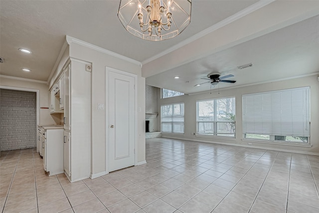 interior space with ornamental molding, light tile patterned floors, a brick fireplace, and white cabinets