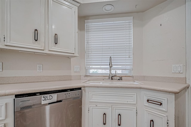 kitchen featuring stainless steel dishwasher, sink, and white cabinets