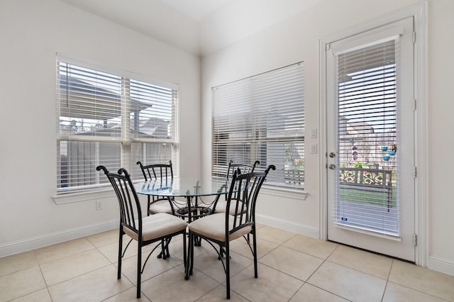 dining space featuring baseboards and light tile patterned flooring