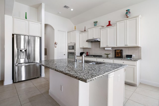 kitchen featuring visible vents, appliances with stainless steel finishes, under cabinet range hood, a sink, and decorative backsplash