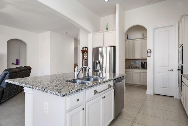 9518 Brannok Ln, Tomball, TX 77375 - kitchen featuring a sink, stainless steel appliances, light tile patterned floors, a kitchen island with sink, and open floor plan