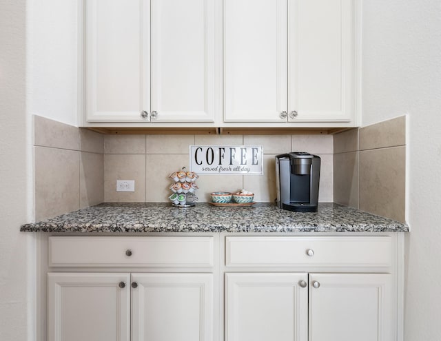 9518 Brannok Ln, Tomball, TX 77375 - kitchen with dark stone countertops, decorative backsplash, and white cabinetry