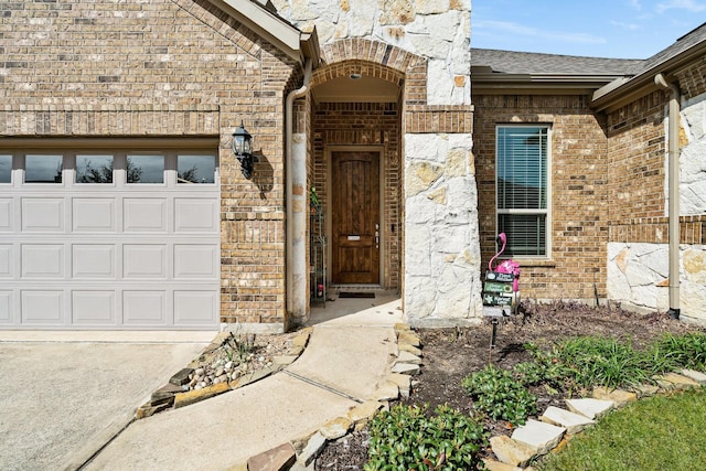 entrance to property featuring brick siding, a shingled roof, and an attached garage