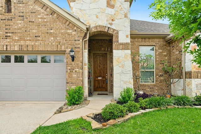 9518 Brannok Ln, Tomball, TX 77375 - doorway to property featuring a garage, brick siding, roof with shingles, and concrete driveway