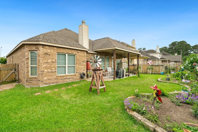 9518 Brannok Ln, Tomball, TX 77375 - back of house with brick siding, a patio, a shingled roof, and a chimney