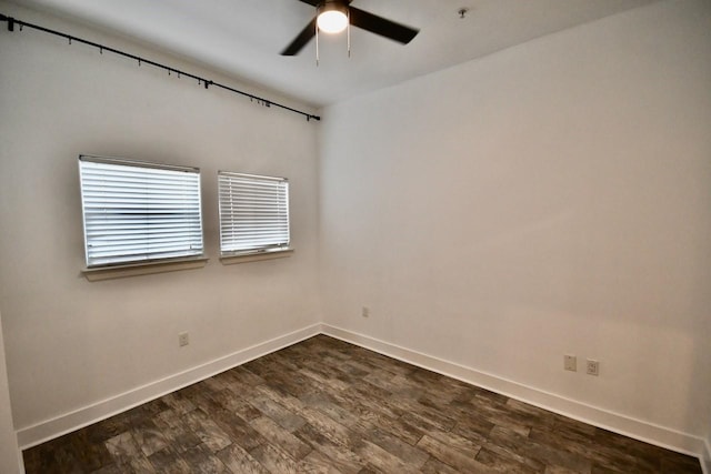 unfurnished room featuring dark wood-style floors, baseboards, and a ceiling fan