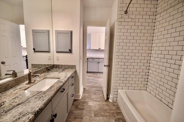 full bathroom with tasteful backsplash, vanity, and shower / tub combination