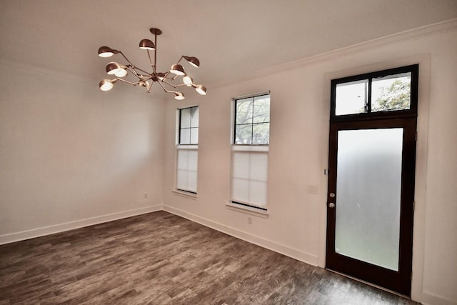 foyer entrance featuring dark wood-style floors, a chandelier, crown molding, and baseboards