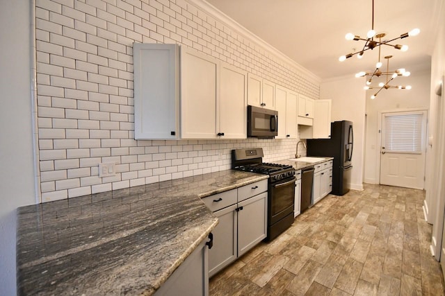 kitchen with dishwasher, ornamental molding, freestanding refrigerator, gas range oven, and backsplash