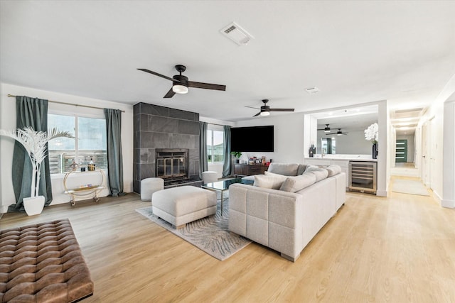 living room featuring wine cooler, plenty of natural light, and light wood-type flooring