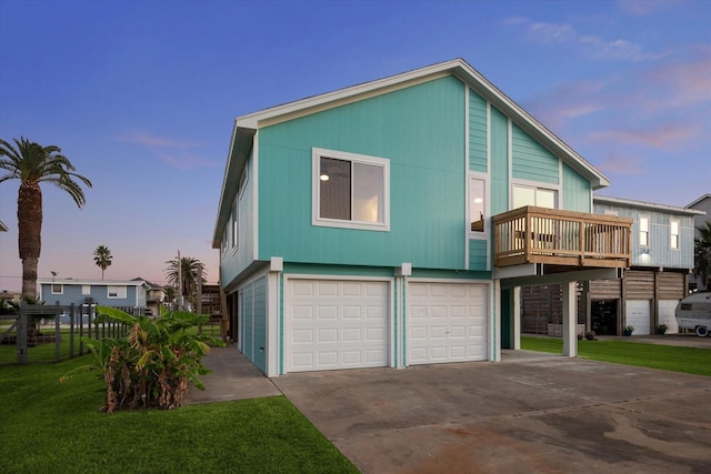 view of front facade featuring a wooden deck, a garage, and a yard