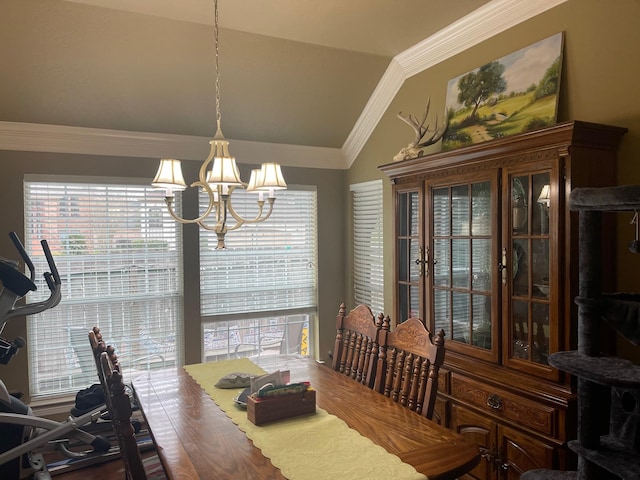 dining room with a healthy amount of sunlight, vaulted ceiling, crown molding, and a notable chandelier