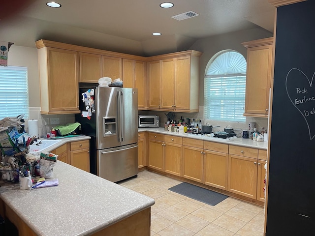 kitchen with light tile patterned flooring, tasteful backsplash, white gas stovetop, and stainless steel fridge with ice dispenser