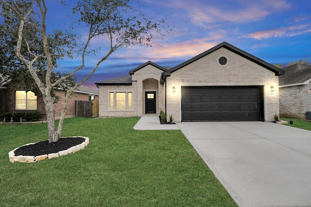 ranch-style home with a garage and a lawn