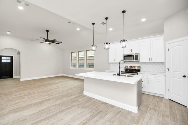 kitchen with a kitchen island with sink, sink, white cabinetry, and stainless steel appliances