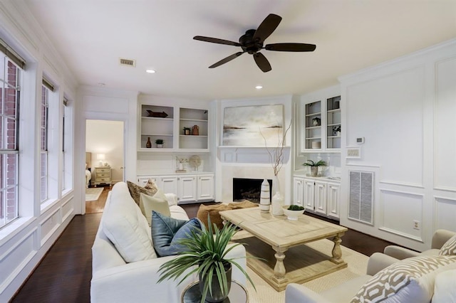 living room featuring crown molding, dark hardwood / wood-style floors, ceiling fan, and built in shelves