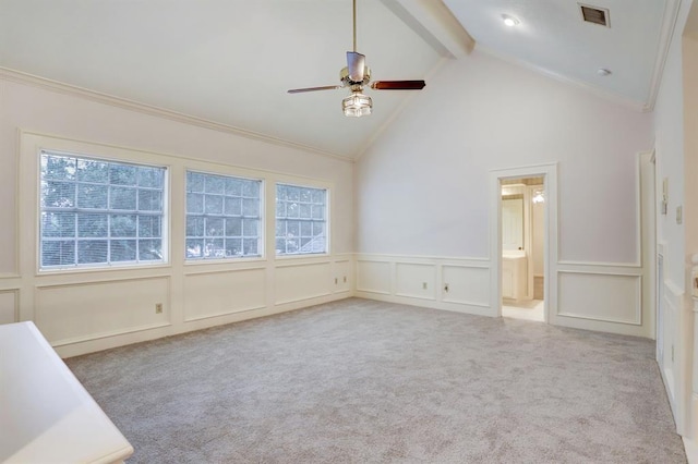 spare room with beamed ceiling, crown molding, and light carpet