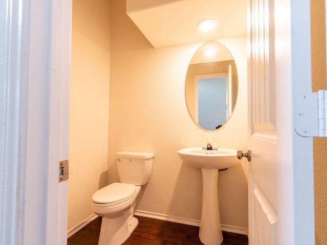 bathroom with hardwood / wood-style flooring and toilet