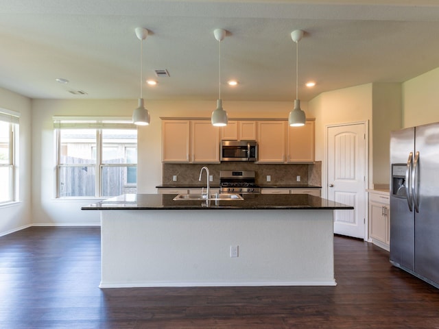 kitchen featuring pendant lighting, appliances with stainless steel finishes, and an island with sink