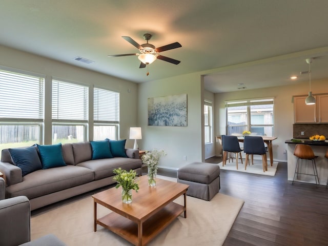 living room featuring dark hardwood / wood-style flooring, a wealth of natural light, and ceiling fan