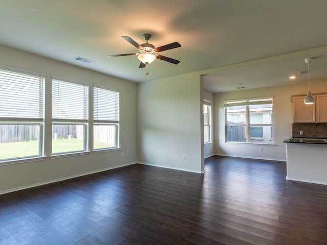 unfurnished living room featuring ceiling fan and dark hardwood / wood-style flooring