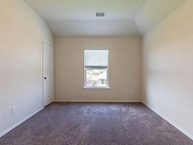 carpeted spare room with vaulted ceiling