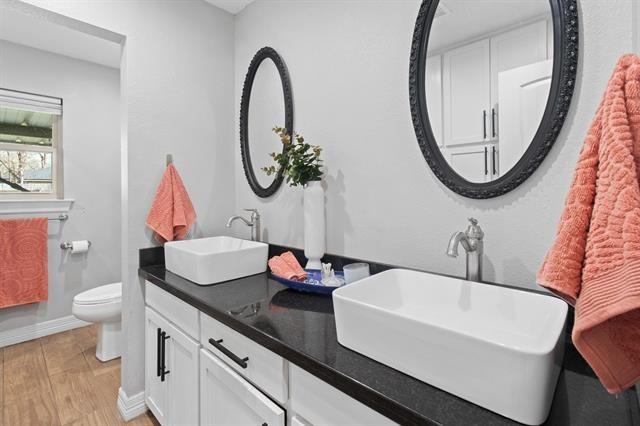 bathroom featuring vanity, wood-type flooring, and toilet