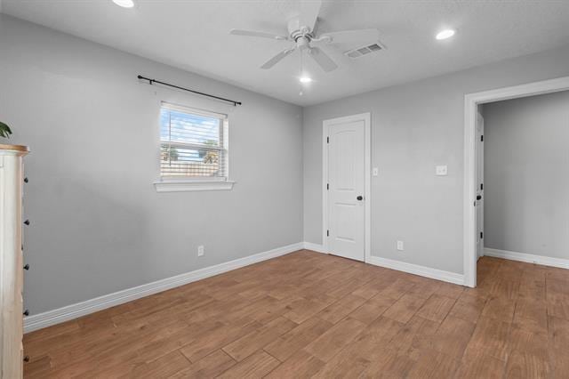 unfurnished bedroom with ceiling fan and light hardwood / wood-style flooring