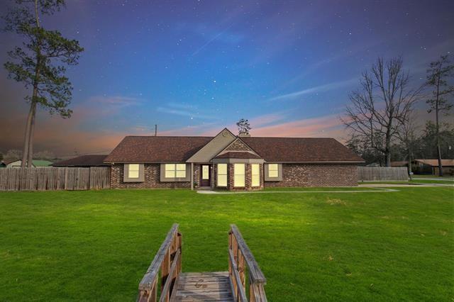 back house at dusk with a lawn