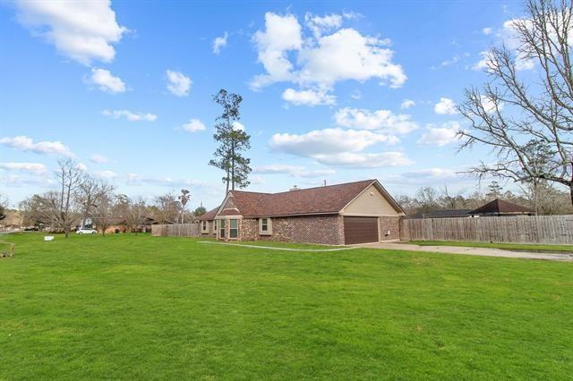 back of house with a garage and a lawn