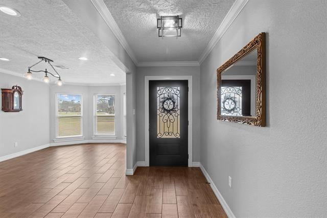 entryway featuring ornamental molding, hardwood / wood-style floors, and a textured ceiling