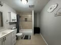 full bathroom with shower / bath combination with curtain, vanity, and toilet