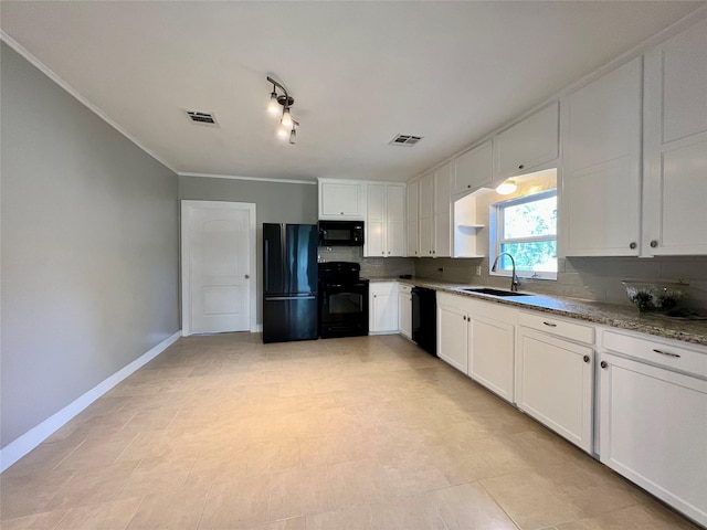 kitchen featuring light stone counters, black appliances, backsplash, sink, and white cabinetry