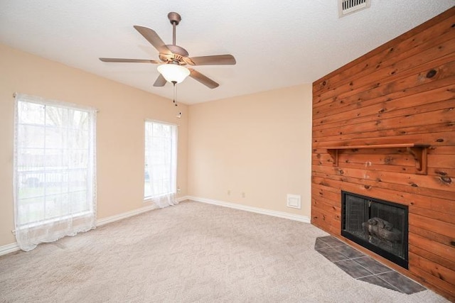 unfurnished living room with baseboards, light colored carpet, a fireplace with flush hearth, and visible vents