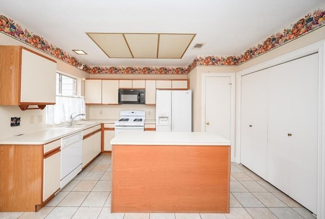 kitchen with white cabinets, light countertops, white appliances, a kitchen island, and a sink