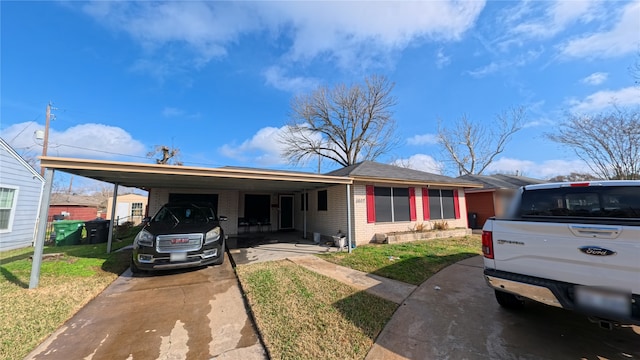 view of front of home with a carport and a front lawn