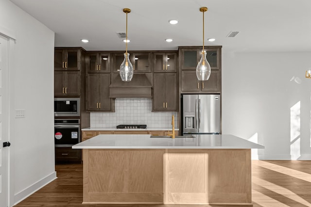 kitchen featuring appliances with stainless steel finishes, a sink, baseboards, light countertops, and recessed lighting