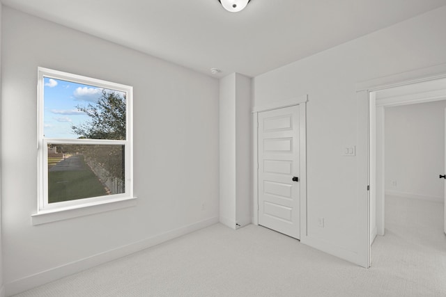 unfurnished bedroom with light carpet, baseboards, and a closet