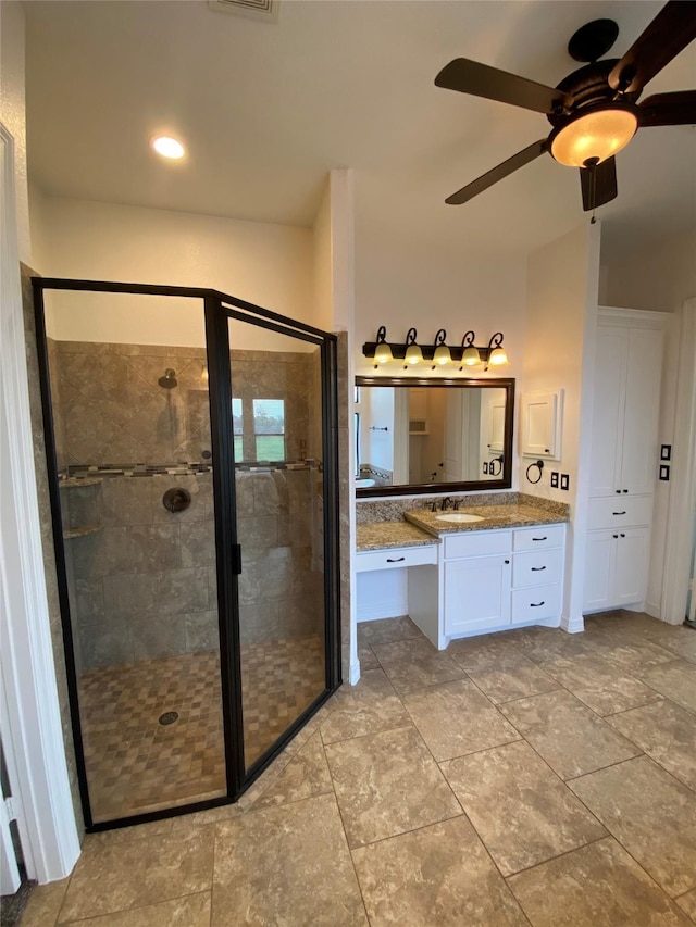 bathroom featuring vanity, a shower with shower door, and ceiling fan