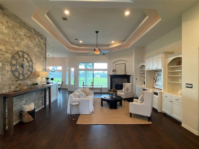 11707 W Grand Pond Dr, Montgomery, TX 77356 - living room featuring dark wood-style floors, a multi sided fireplace, visible vents, a tray ceiling, and ceiling fan