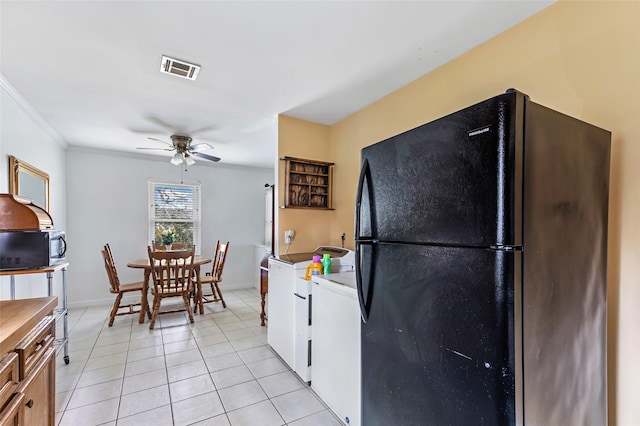 kitchen featuring washer / dryer, ornamental molding, light tile patterned floors, ceiling fan, and black appliances