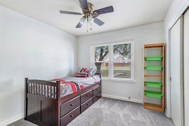 bedroom featuring ceiling fan, light colored carpet, and a closet