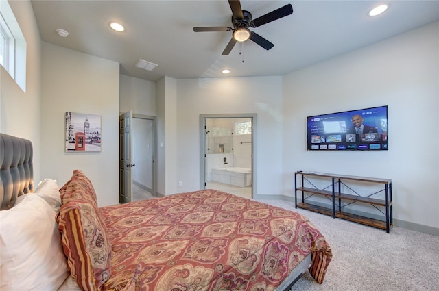 carpeted bedroom featuring multiple windows, ceiling fan, and ensuite bath