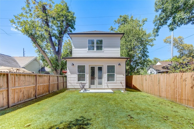 rear view of house featuring a yard and french doors