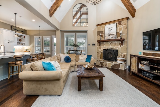 living room with beamed ceiling, dark hardwood / wood-style flooring, high vaulted ceiling, and a stone fireplace